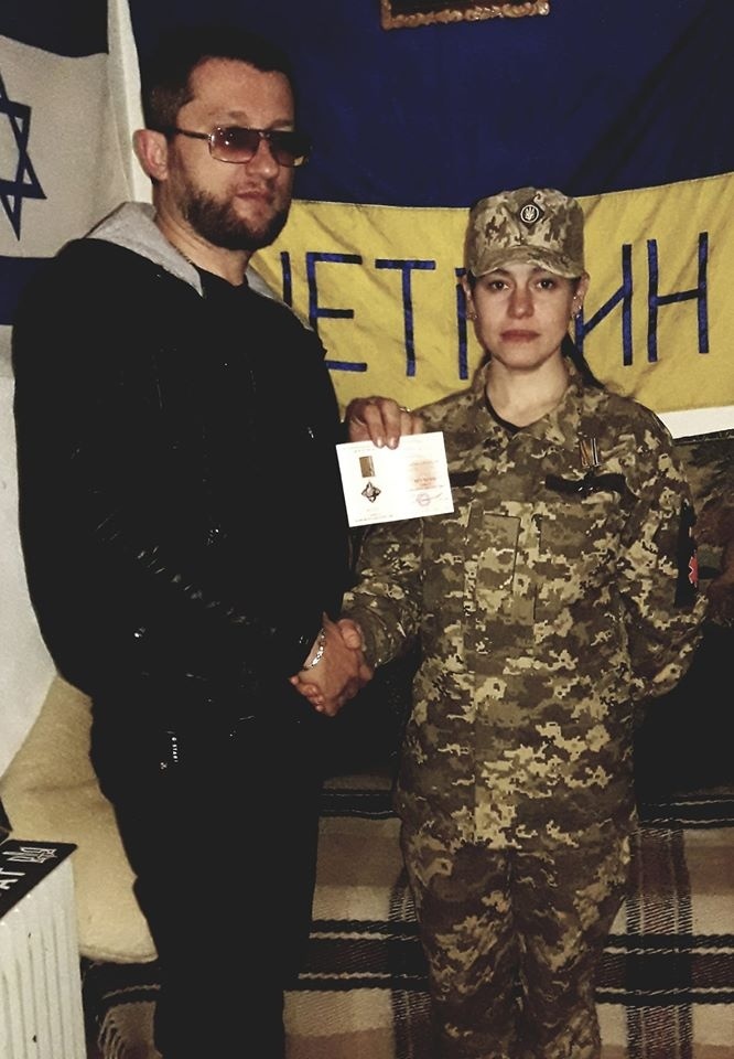 М. Хорєв вручає О. Мірковій відзнаку "Хрест бойового братерства".